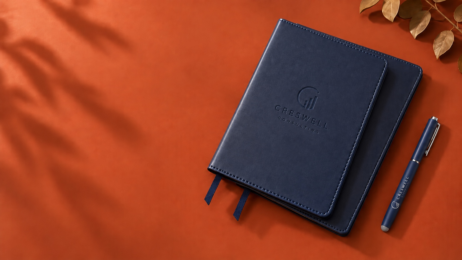 Carnets et stylo bleu marine personnalisés pour les entreprises sur fond terracotta